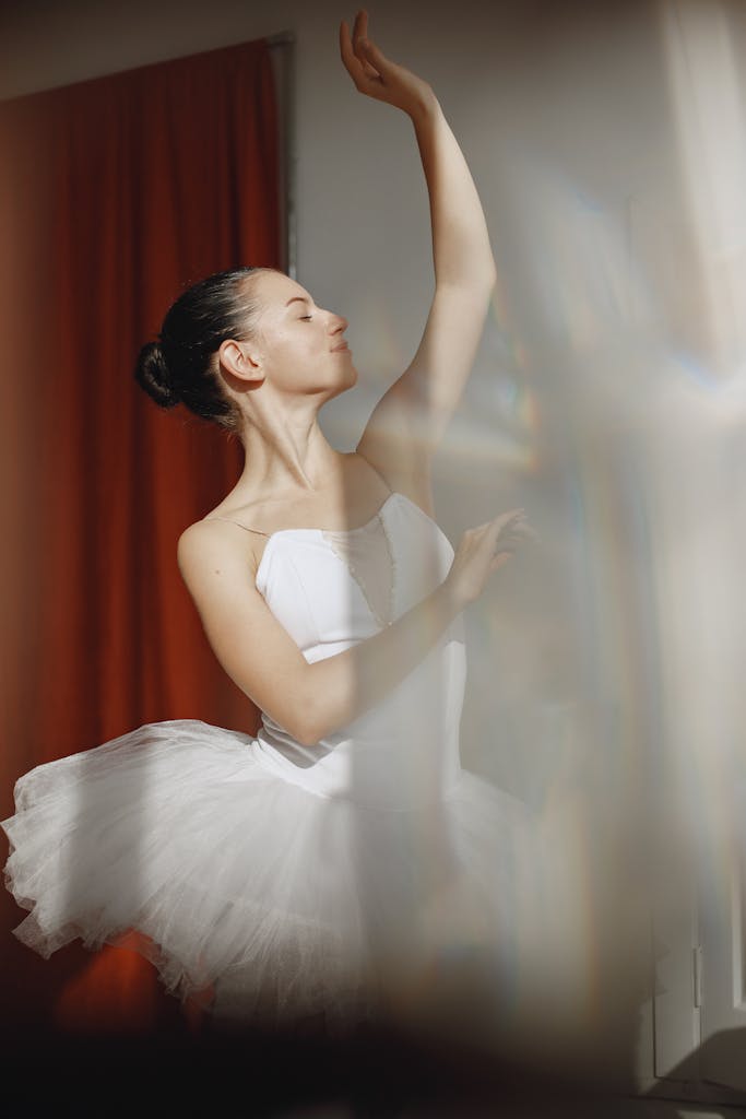 Hair loss nutrition Graceful ballet dancer performing elegantly in a white tutu indoors.