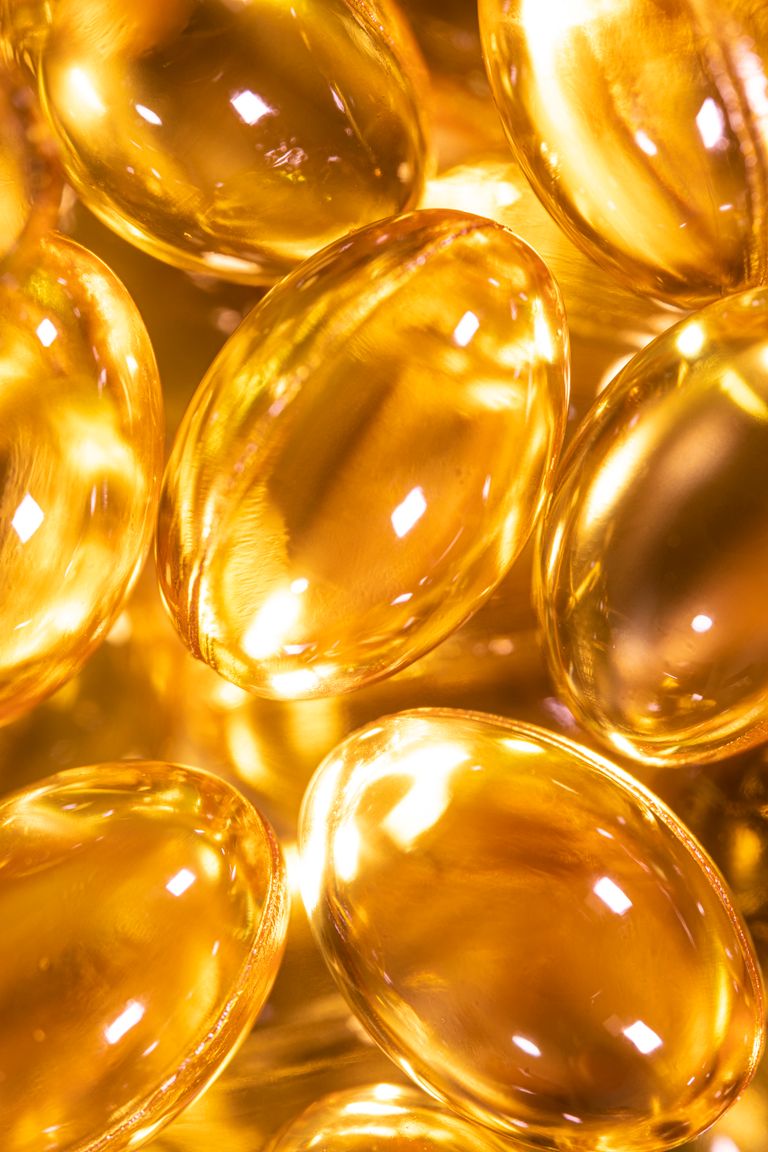Bright close-up image of golden Omega-3 supplement gel capsules, ideal for health and wellness themes.