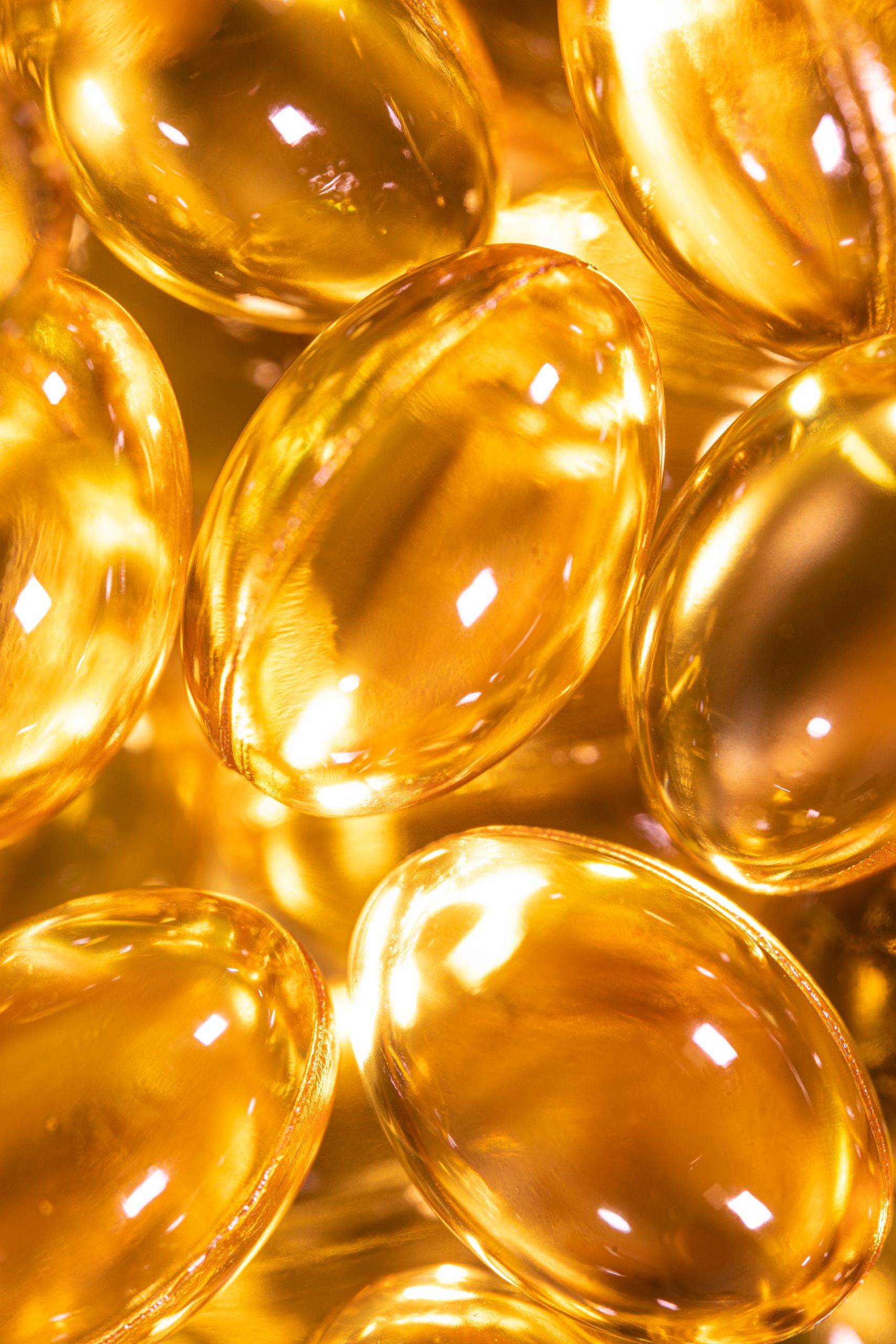Bright close-up image of golden Omega-3 supplement gel capsules, ideal for health and wellness themes.