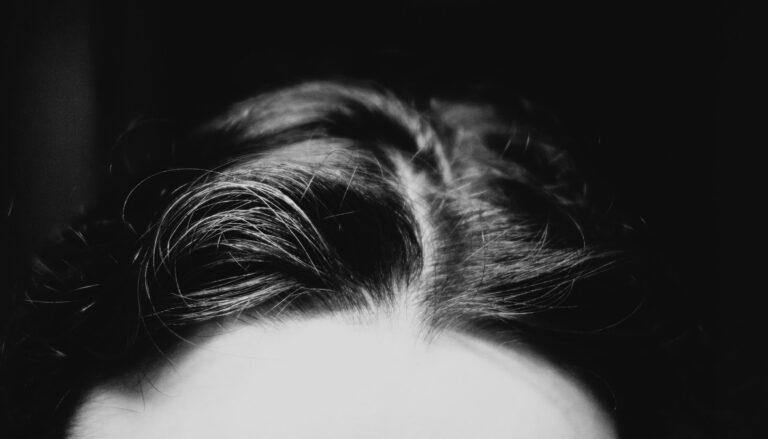 Close-up black and white image of hair scalp microbiome with dramatic lighting creating a mysterious vibe.