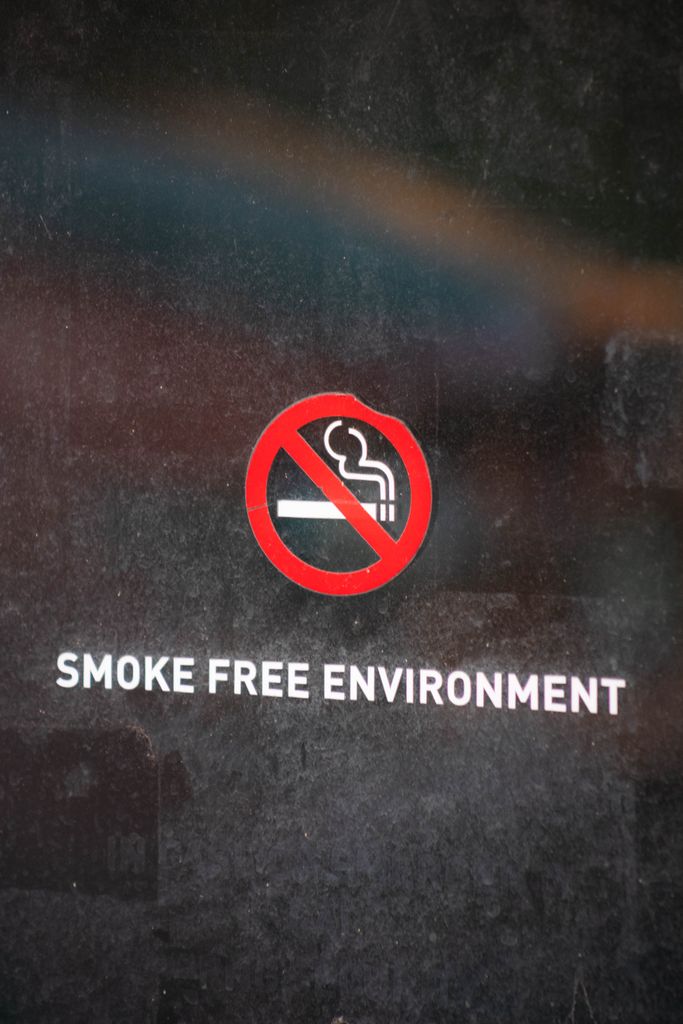 Close-up of no smoking sign indicating a smoke-free environment on a reflective surface.