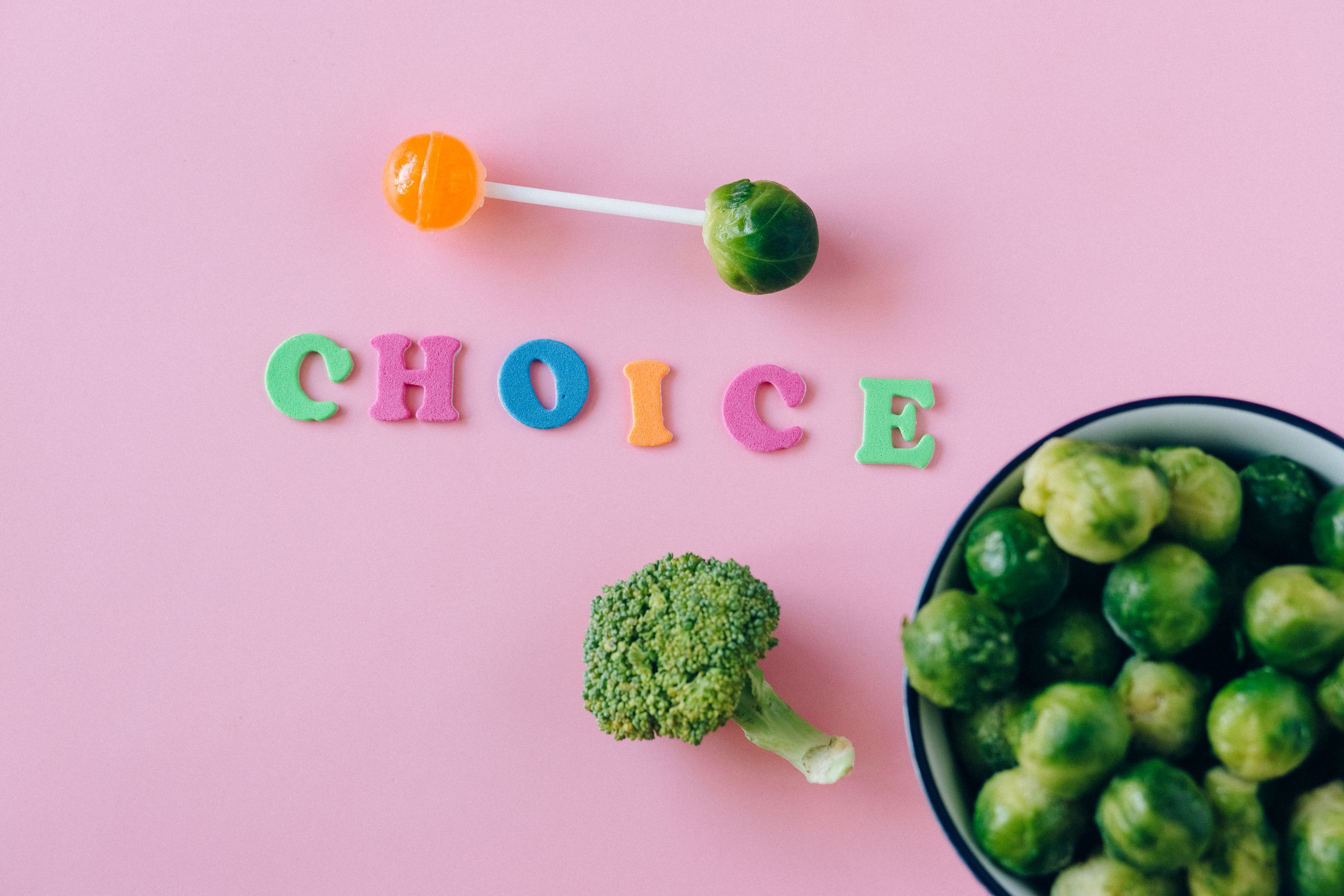 Colorful depiction of healthy and sweet food choices on pink backdrop.