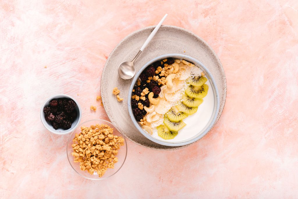 Delicious yogurt bowl topped with fresh kiwi, cashews, and mixed berries, perfect for a healthy breakfast.